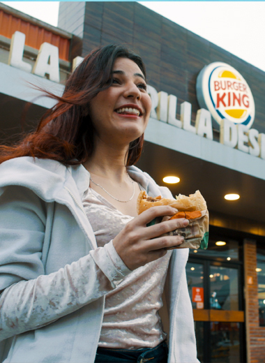 Muchacha probando una hamburguesa durante un spot comercial