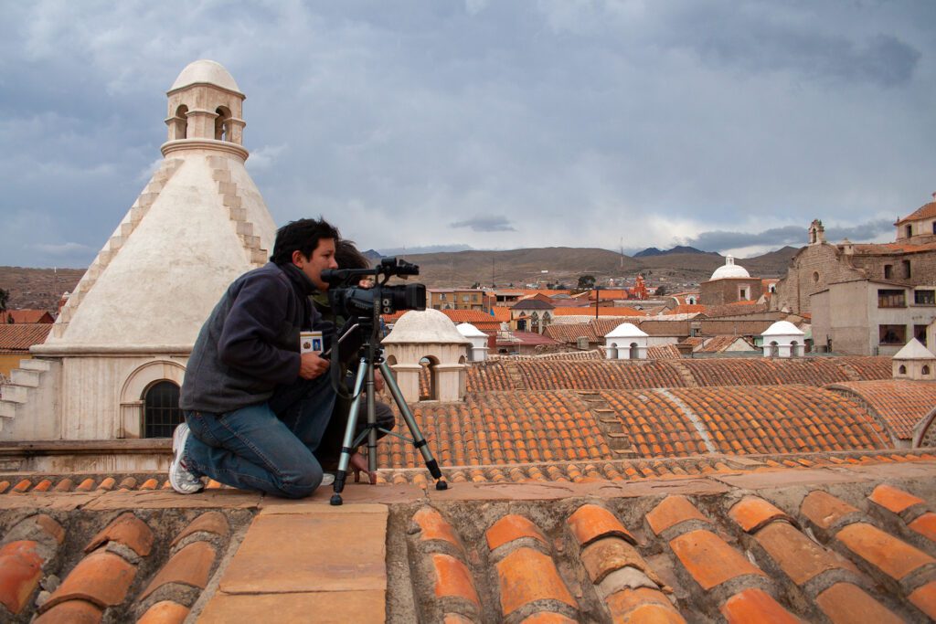 Camarógrafo y asistente de fotografía registrando imágenes de Potosí desde el techo de la Casa de la Moneda